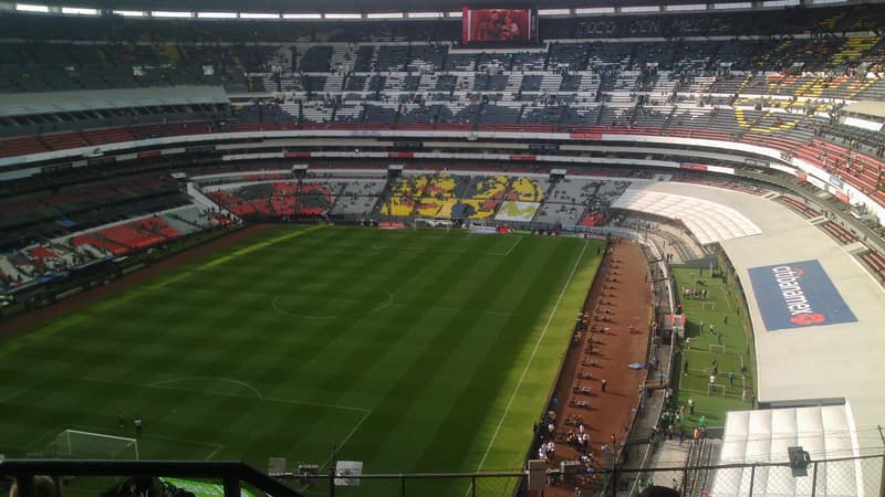 Interior real del Estadio Azteca de la Ciudad de México: vista desde la tribuna alta hacia la cancha y las cabeceras, antes de un partido